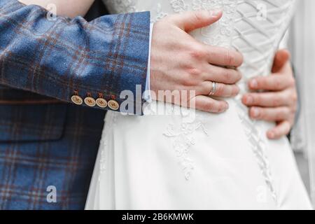 Stilvolles Hochzeitspaar, das draußen umarmt Stockfoto