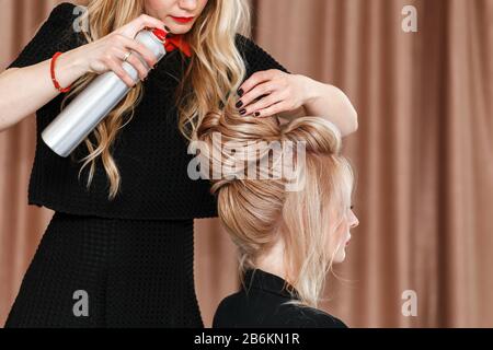 Der Blick auf einen Friseursalon macht die Abendfrisur zum blonden Modell im Salon Stockfoto
