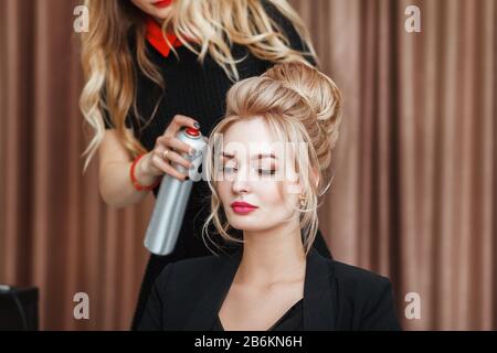 Der Blick auf einen Friseursalon macht die Abendfrisur zum blonden Modell im Salon Stockfoto