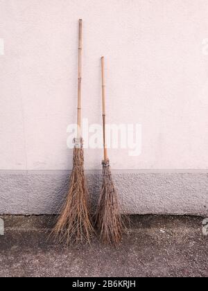 Nahaufnahme von zwei traditionellen handgefertigten Besen mit langen Griffen sowie kurzen Griffen. Stockfoto