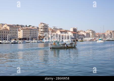 Ein kleines Fischerboot, das den Alten Hafen von Marseille, Frankreich, verlässt. Stockfoto