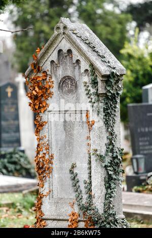 24. MÄRZ 2017, WIEN, ÖSTERREICH: Alte, zerstörte und überwucherte Denkmäler auf Gräbern auf dem Wiener Zentralfriedhof Stockfoto