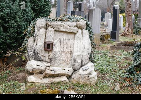 Alte, zerstörte und überwucherte Denkmäler auf Gräbern auf dem Wiener Zentralfriedhof Stockfoto