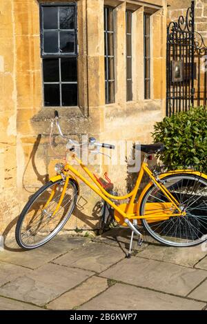 Ein gelbes Veuve Clicquot Fahrrad außerhalb des gelben Steins des Lygon Arms Hotel im Cotswold Dorf am Broadway, Worcestershire UK Stockfoto