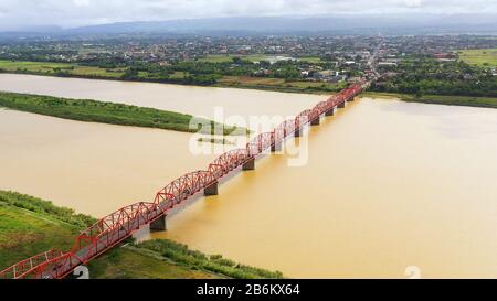 Brücke über den Cagayan River, Philippinen, Luftbild. Straßenbrücke über einen breiten Fluss. Autos fahren auf der Brücke. Stockfoto