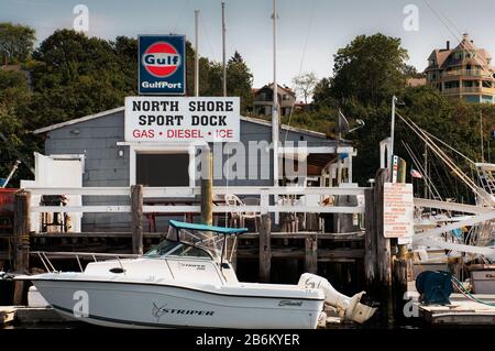Das North Shore Sport Dock ist eine klassische Einrichtung am Gloucester Harbour. Der Blick winkt einem Tag vorbei an einfacheren Zeiten. Das einstöckige Gebäude aus grauem Holz Stockfoto