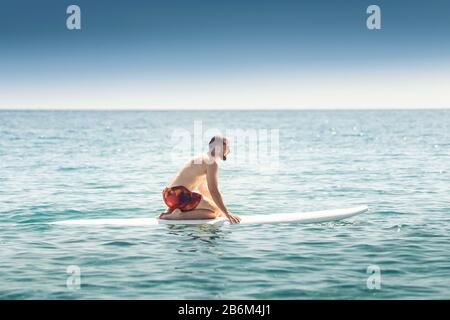 Ein Mann lernt, auf dem offenen Meer mit einem Wasserbrett zu fahren Stockfoto