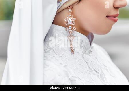 Charmante muslimische Brautpaar in Nikah-Hochzeitskleid, Nahaufnahme von Schmuck und Ohrringen Stockfoto