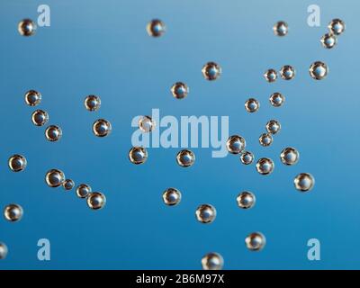 Makro der Luftblasen auf Wasserglas mit blauem Hintergrund Stockfoto
