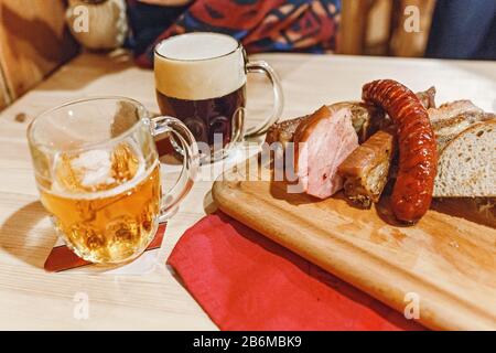 Zwei Tassen Bier und Schweinefleisch auf dem Tisch in der tschechischen Kneipe Stockfoto