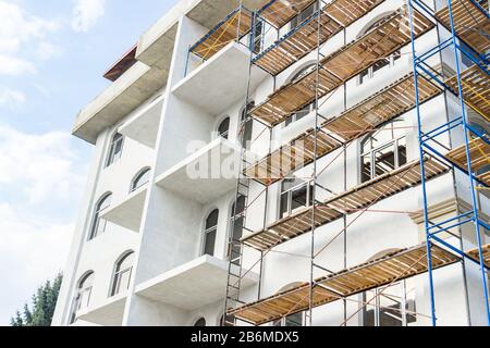 Umfangreiches Gerüst für den Bau eines neuen Hauses. Konstraktion von Plattformen für Baumaßnahmen. Stockfoto