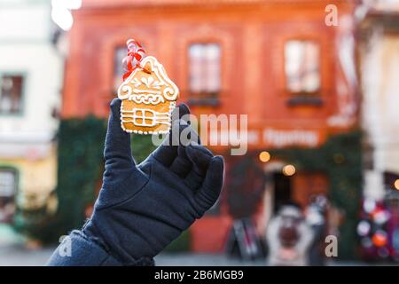 Eine Frau hält ein traditionelles Lebkuchen vor dem Hintergrund einer Weihnachtsstraße in Tschechien Stockfoto