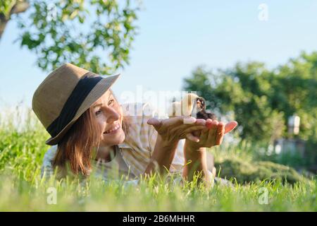 Frau Bauer hält zwei kleine neugeborene Babyhühner in den Händen Stockfoto