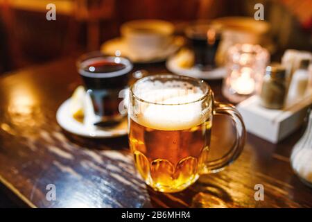 Glas handgefertigtes Bier im Vintage-Becher auf dem Tisch in einer Bar Stockfoto