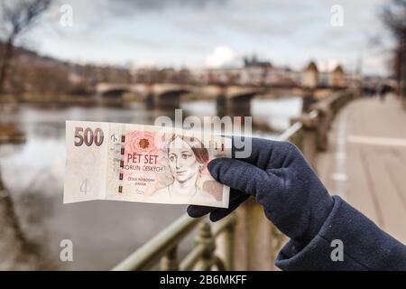 Tschechische Kronenbanknote vor dem Hintergrund der Prager Stadt Stockfoto
