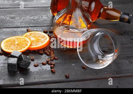 Whiskey oder Likör, Kaffeebohnen und Orange auf Holzgrund geschnitten. Saisonales Urlaubskonzept. Stockfoto