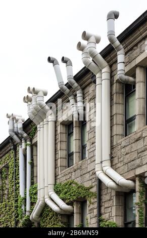 Fassade eines alten Gebäudes mit Kunststoff-Entlüftungsrohren Stockfoto