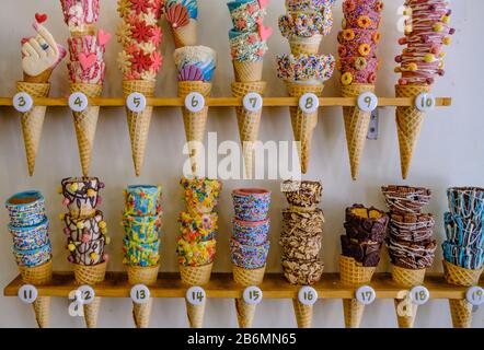 Buntes Eis mit farbenfrohem Süßigkeiten-Display im Regal Stockfoto