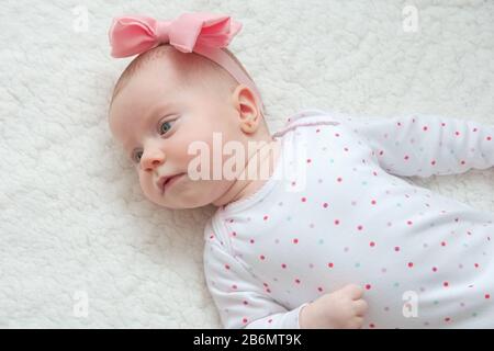 Adorable Baby Girl mit Pink Hair Band Posiert auf Photoshoot Stockfoto