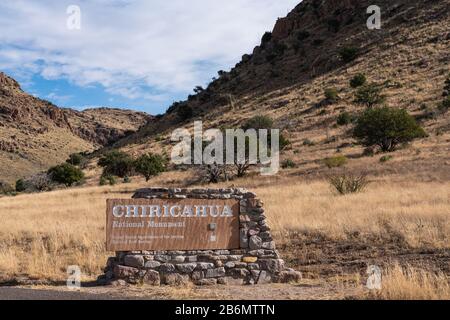 Willcox, AZ - 24. November 2019: Steinernes Eingangsschild zum Chiricahua Natonal Monument bei Willcox im Südosten Arizonas mit Gräsern und Bäumen auf der mou Stockfoto