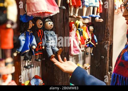 Kunde der Frau, die sich die traditionellen Marionetten aus Holz im Shop anschaut Stockfoto