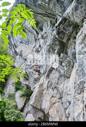 Frau, die auf der schwierigen Kletterroute Zimmereben, in der Nähe von Mayrhofen, Zillertal, Österreich, beeindruckende Felsformationen erklimmt, eine Route wird empfohlen Stockfoto