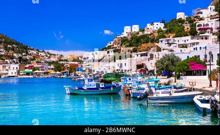 Traditionelle Windmühlen, weiße Häuser und Fischerboote am Panteli-Strand, Insel Leros, Griechenland. Stockfoto