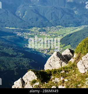 Gosaudorf und Tal in Österreich, umgeben von Grünwäldern - Blick von einer Kletterroute im Donnerkogelgebirge. Stockfoto