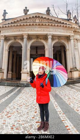 Frau Touristin mit Regenschirm beim Winterspaziergang in der Nähe der Mlynska Colonnade in Karlsbad, Tschechien Stockfoto