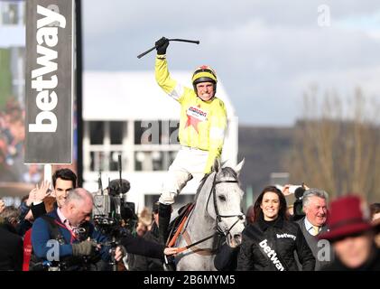 Politologe, der vom Jockey Harry Skelton geritten wird, feiert den Sieg im Betway Queen Mother Champion Chase am zweiten Tag des Cheltenham Festivals auf der Cheltenham Racecourse. Stockfoto