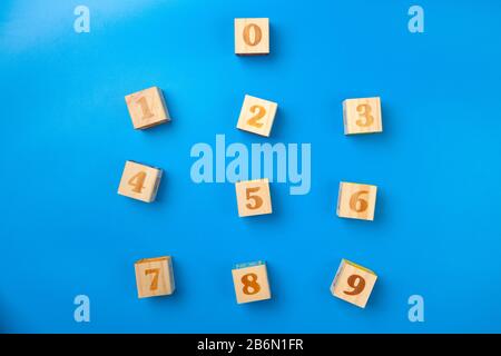 Zahlen. Bunte Holz-Alphabet-Blöcke auf blauem Hintergrund, flacher Lay, Draufsicht. Stockfoto