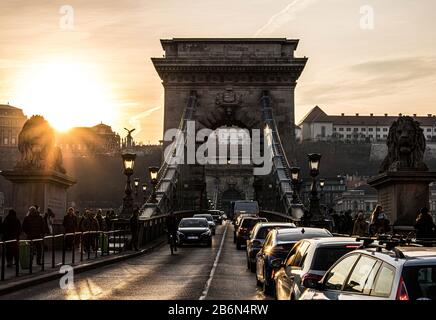 Budapester Kettenbrücke (Szechenyi Lanchid) bei Sonnenuntergang, Foto von der Straße Stockfoto