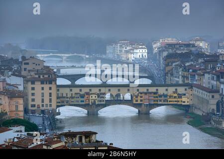 FLORENZ ITALIEN STARKER MORGENNEBEL ÜBER BRÜCKEN AM FLUSS ARNO DIE FARBIGE PONTE VECCHIO IM VORDERGRUND Stockfoto