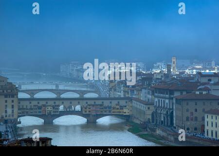 FLORENZ ITALIEN MORGENNEBEL ÜBER BRÜCKEN AM FLUSS ARNO DIE FARBIGE PONTE VECCHIO IM VORDERGRUND Stockfoto