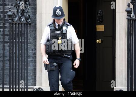 Ein Polizeibeamter verlässt die 10 Downing Street, london, Großbritannien Stockfoto