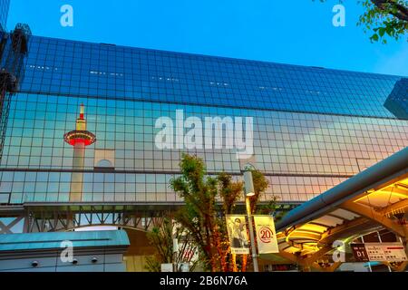 Kyoto, Japan - 27. April 2017: Kyoto-Turm mit Aussichtsplattform, reflektiert auf der Glasfassade des Stationsgebäudes von Karasuma-Seite. Die Kyoto-Station ist eine Stockfoto