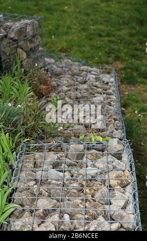 Gabionen in einem mit Steinen gefüllten Garten Stockfoto