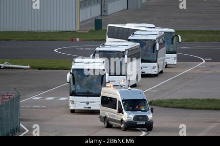 Reisebusse, Rettungswagen und Taxis machen sich auf den Weg, um Passagiere von der von Coronavirus heimgeprallten Grand Princess bei ihrer Ankunft am Flughafen Birmingham zu holen, nachdem sie aus den USA zurückgebracht wurden. Stockfoto