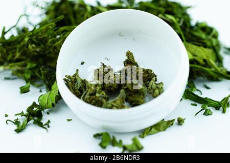 Makro der entspannenden medizinischen CBD Pflanzen Marihuana-Blume-Knospe in einer weißen medizinischen Box mit großem Knospenstapel und Marihuana-Blättern Stockfoto