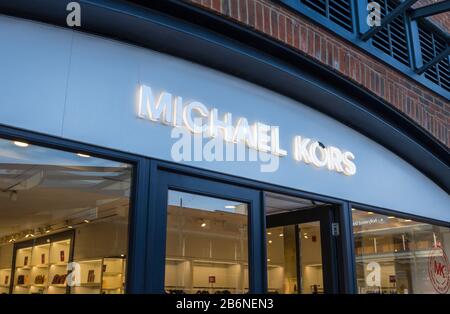 Namensschild und Logo für Michael Kors, Luxusdesignerartikel, über der Ladenfront, Gunwharf Quays Einkaufszentrum, Portsmouth, Hampshire, Südengland Stockfoto