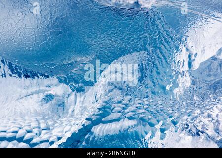 Abstraktes Muster in schmelzender Eisscholle/Eisberg, das Textur durch Schmelzwasser/Schmelzwasser zeigt Stockfoto