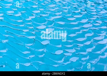 Abstraktes Muster in schmelzender Eisscholle/Eisberg, das Textur durch Schmelzwasser/Schmelzwasser zeigt Stockfoto