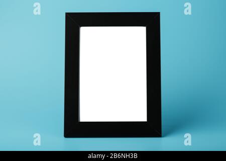 Schwarzer Bilderrahmen mit leerem Raum auf blauem Hintergrund. Minimalistisches Konzept mit Raum für Bild und Text. Stockfoto