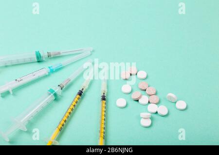Medikamente Pillen und Spritzen auf Farbhintergrund. Gesundheitswesen, Coronavirus Konzept Stockfoto