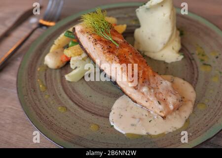 Gerösteter Lachs mit pommes frites und Gemüsesalat. Stockfoto