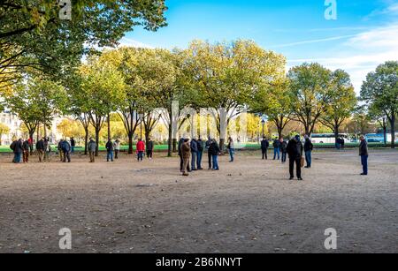Die Teams der Spieler nehmen am klassischen französischen Petanque Boule Game im Park Les Invalides, Paris, Frankreich Teil Stockfoto