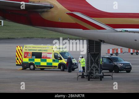 Ein Mitglied des NHS West Midlands Ambulance Service, das Schutzkleidung und eine Gesichtsmaske trägt, spricht mit den Passagieren (links) vom von Coronavirus geschlagenen Kreuzfahrtschiff Grand Princess, nachdem sie nach ihrer Rückführung aus den USA auf den Flughafen Birmingham angekommen sind. PA Foto. Bilddatum: Mittwoch, 11. März 2020. Rund 140 britische Urlauber waren vor der Westküste Amerikas auf dem Schiff gestrandet, nachdem 21 Menschen positiv auf das Virus an Bord getestet hatten. Siehe PA Story HEALTH Coronaviru. Der Lichtbildkredit sollte lauten: Steve Parsons/PA Wire Stockfoto