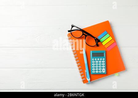 Copybook, Brille, Taschenrechner, Stift und Aufkleber auf Holzhintergrund, Platz für Text Stockfoto