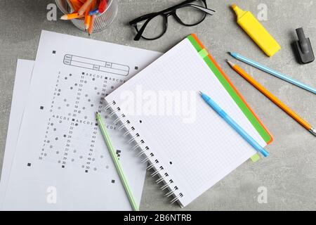 Testblätter, Copybook, Brille und stationär auf grauem Hintergrund, Draufsicht Stockfoto