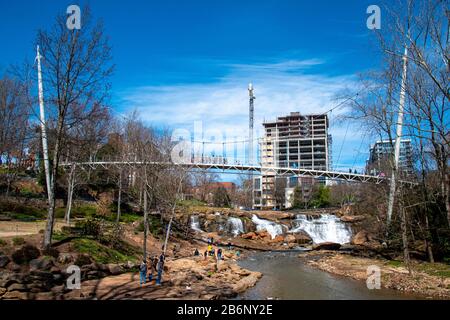 Blick auf den Falls Park an der Reedy mit Hängebrücke und Wasserfall in Greenville, South Carolina Stockfoto